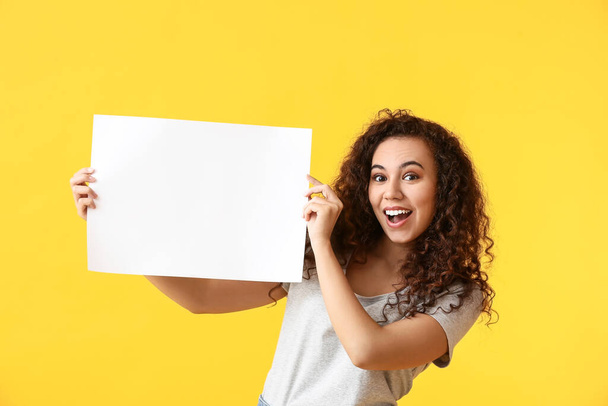 Young woman with blank poster on color background - Photo, Image