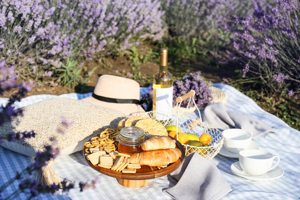 Tasty food and drink for romantic picnic in lavender field - Photo, Image