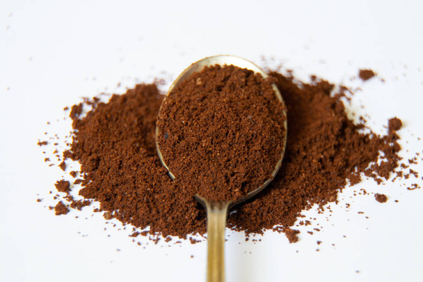 a spoonful of ground coffee on a white background close up - Valokuva, kuva