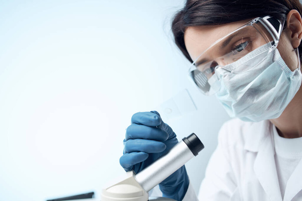 woman wearing medical mask laboratory microscope science research - Фото, изображение