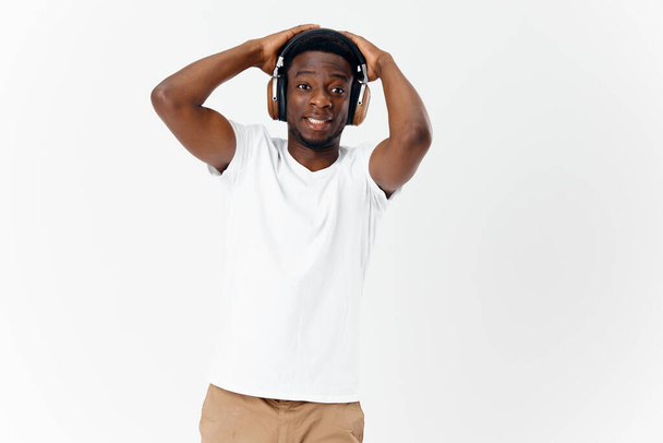 Емоційний афроамериканець у навушниках з сучасною технологією музики. - Фото, зображення