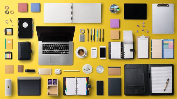 Flat lay top view office desk working space with laptop on yellow background. - Foto, Imagem