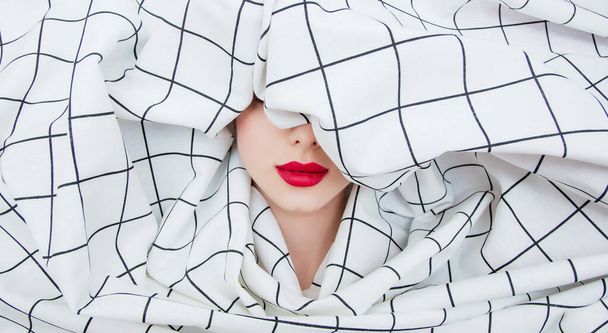 Portrait of a young girl with red lipstick shrouded checkered fabric  - Foto, Imagem