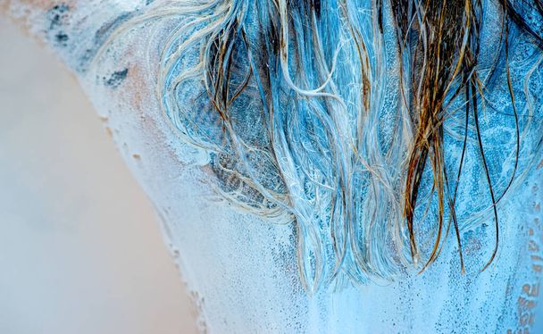Detalle del cabello empapado en pintura azul y blanca en la parte posterior de una mujer joven, espacio para copiar - Foto, imagen