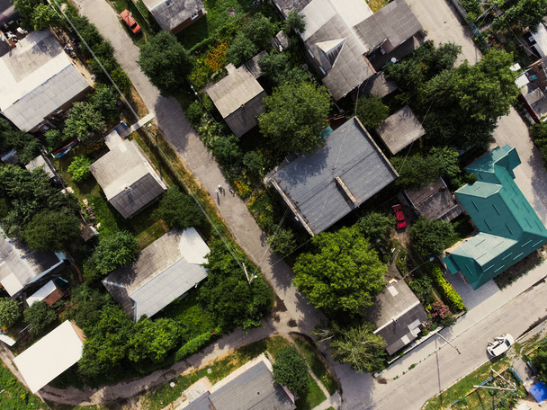Aerial view of suburb of European city. Green neighbourhood on a sunny summer day. County living. Drone point of view - 写真・画像