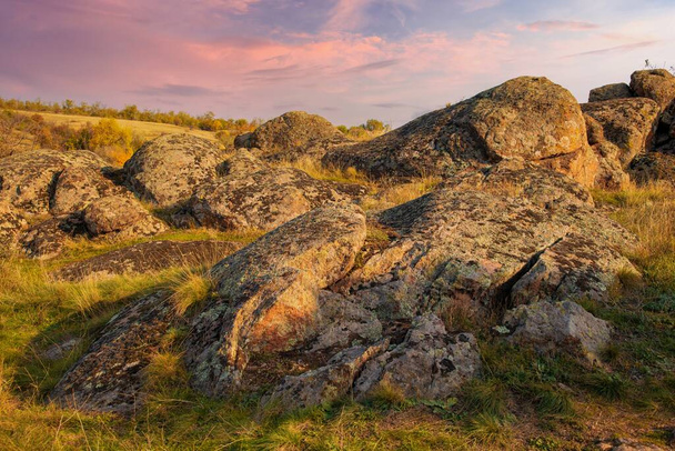 A small pile of stones in a green-yellow field against the background of a sky in Ukraine - Valokuva, kuva