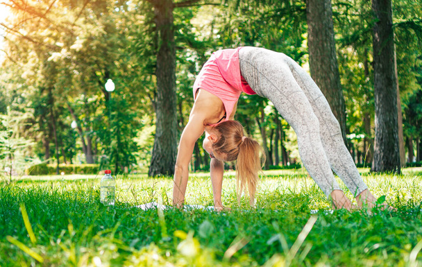 Yogi woman workout in a city park. Bridge pose. - Фото, изображение
