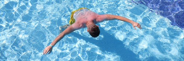 Young man swimming in pool top view - Photo, Image