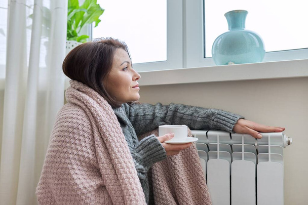 Winter season, woman warming up near home heating radiator - Zdjęcie, obraz