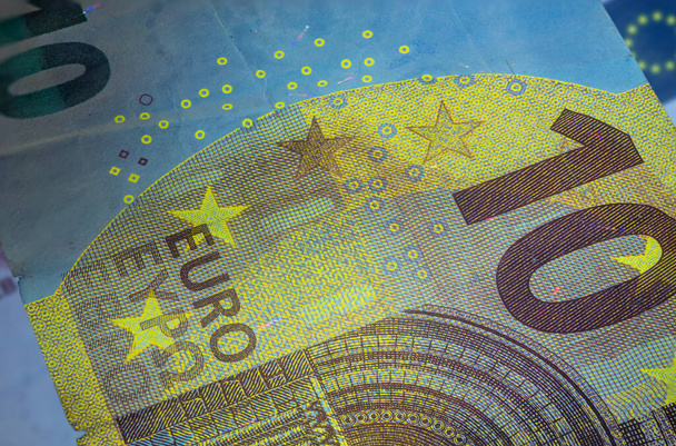 Zehn-Euro-Schein unter fluoreszierendem UV-Licht. Großes Makrobild des europäischen Geldes, das mit Fluorlicht beleuchtet wird. Papiergeld der Europäischen Zentralbank. Ausführlicher Zehn-Euro-Schein. 10 Euro - Foto, Bild