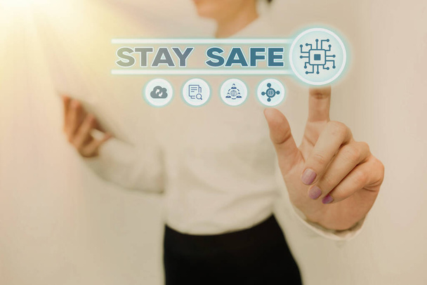 Conceptual caption Stay Safe. Concept meaning secure from threat of danger, harm or place to keep articles Lady Holding Tablet Pressing On Virtual Button Showing Futuristic Tech. - Foto, afbeelding