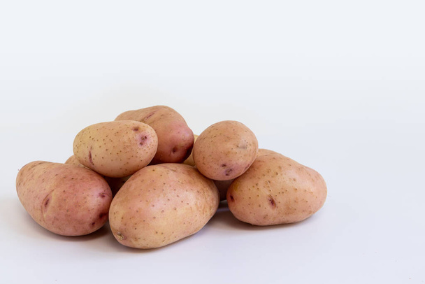 sterta świeżych surowych ziemniaków izolowanych na białym tle, surowe warzywa, zbiory nowych czerwonych ziemniaków, widok z boku - Zdjęcie, obraz