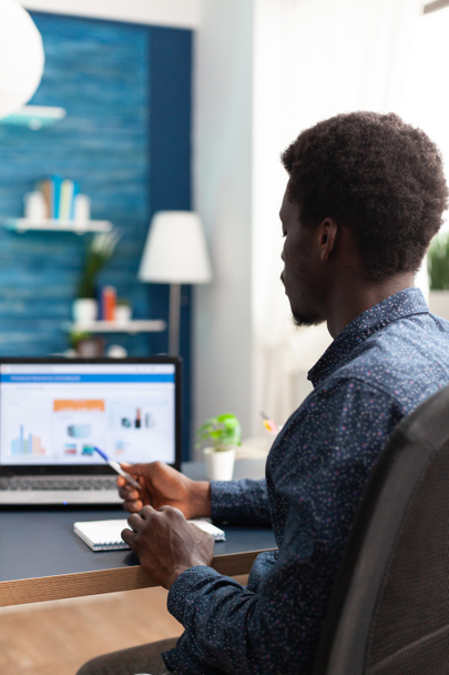 Homem negro trabalhando em casa usando o aplicativo de dados de economia financeira - Foto, Imagem