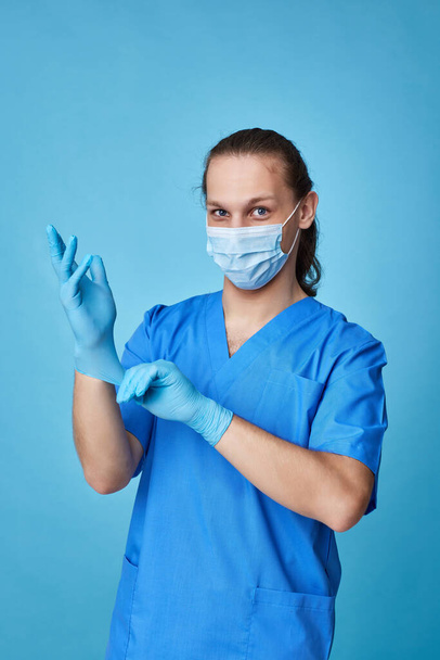 young man doctor in uniform wearing gloves - Photo, image