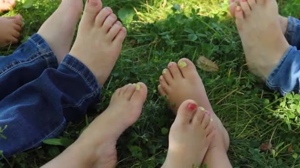 blote tenen bewegen. Sluiten van blote voeten. kinderen die op het gras rusten  - Video