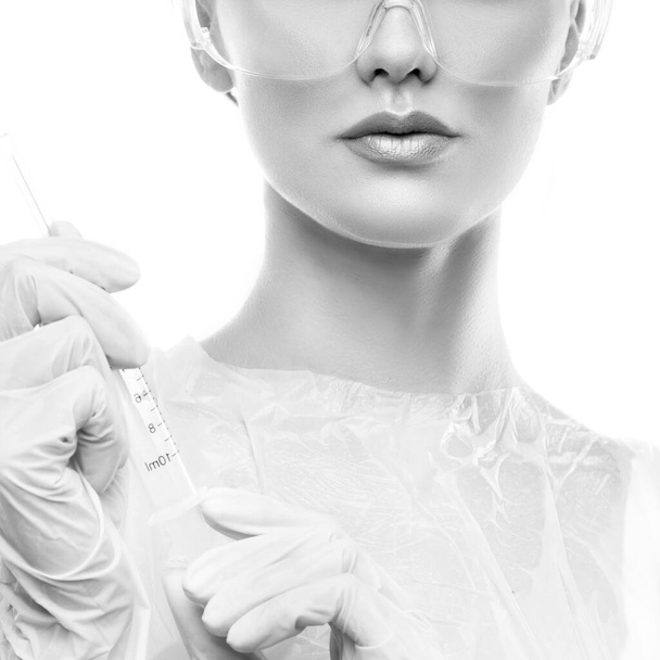 Vrouwelijke arts tandarts of verpleegkundige met medische handschoenen en een bril over een witte achtergrond. Studio portret. - Foto, afbeelding