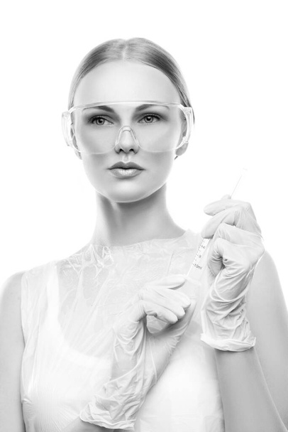 Vrouwelijke arts tandarts of verpleegkundige met medische handschoenen en een bril over een witte achtergrond. Studio portret. - Foto, afbeelding