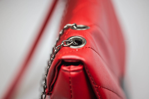 Close-up van een rode leren vrouw handtas. Roodkorrelige leren tas. Modeconcept. Rode luxe leren dameshandtas. Detail bovenaanzicht modieuze tas.  - Foto, afbeelding