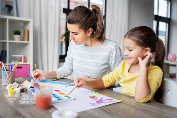mother with little daughter drawing at home - 写真・画像