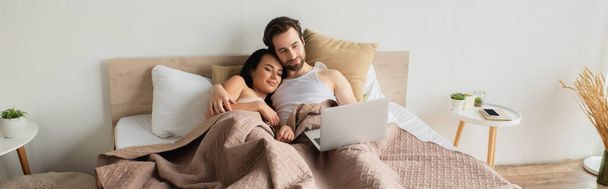 happy couple lying in bed and watching movie on laptop, banner - Photo, Image