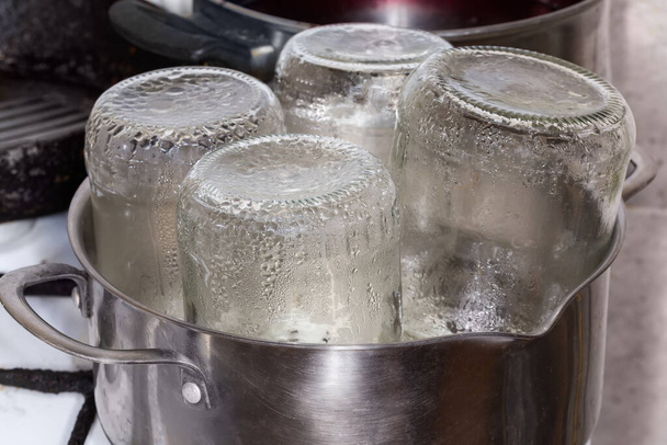 Frascos de vidro no pote de aço inoxidável durante a esterilização a vapor sobre o vapor para o enlatamento em casa - Foto, Imagem