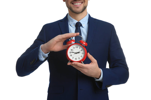 Happy businessman holding alarm clock on white background, closeup. Time management - Valokuva, kuva