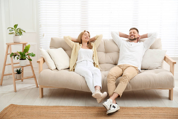 Couple relaxing on sofa in living room - Foto, imagen