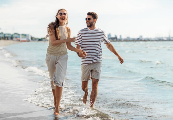 happy couple running along summer beach - Fotoğraf, Görsel