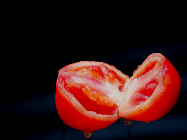 Double piece of sliced tomato isolated on black background, Organic commercial food image. - Φωτογραφία, εικόνα
