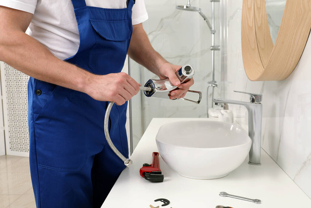 Professional plumber fixing water tap in bathroom, closeup - Photo, image