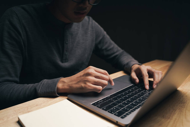 Close-up de um homem usando um computador portátil na mesa de madeira, à procura, navegação, mídia social, mensagem, e-mail, marketing digital na internet, compras on-line - Foto, Imagem