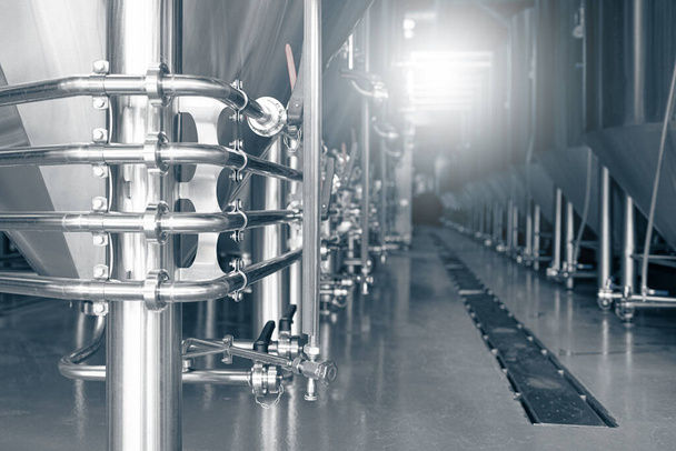 Приватна мікропивоварня. Сучасний пивний завод з пивоварними чайниками, трубами та резервуарами з нержавіючої сталі
 - Фото, зображення