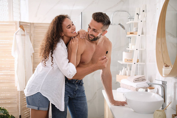 Lovely couple enjoying each other while brushing teeth in bathroom - 写真・画像