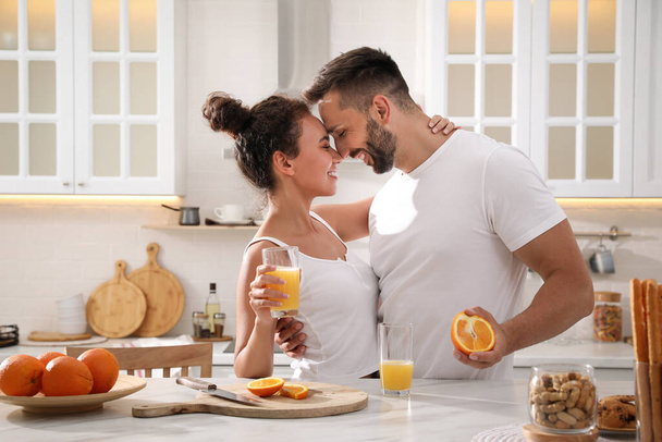 Lovely couple enjoying time together during breakfast at table in kitchen - Foto, Imagem