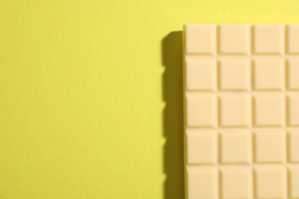 Delicious white chocolate bar on yellow background, top view. Space for text - Foto, afbeelding