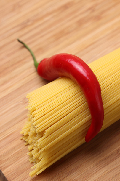 Uncooked pasta and chili peppers - Foto, afbeelding