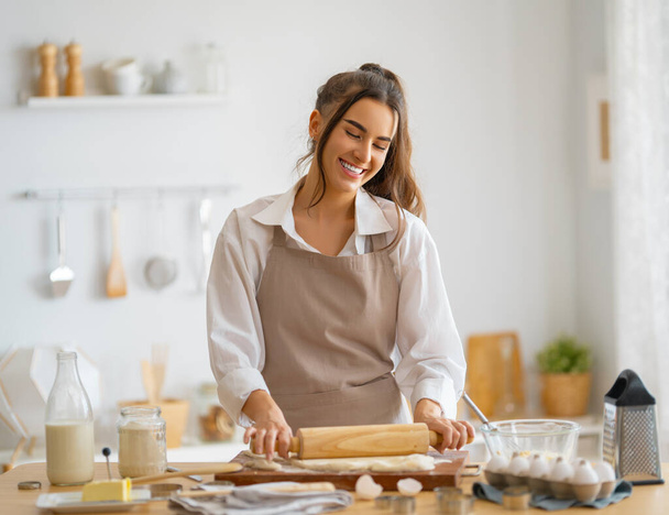 Happy woman is preparing bakery. Girl is cooking cookies in the kitchen. Homemade food. - Fotografie, Obrázek