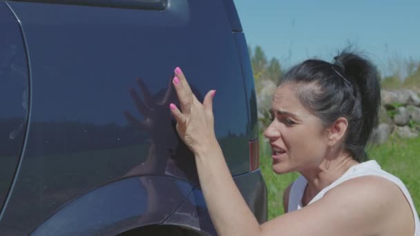 Mujer mostrando arañazos en el coche - Metraje, vídeo