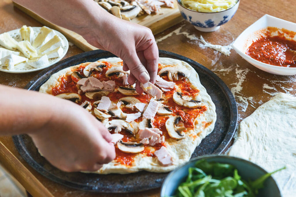 Valmistan italialaista pizzaa nimeltä Margherita. Hiiva taikina pizza sieniä, mozzarella juustoa ja tomaattikastiketta. - Valokuva, kuva