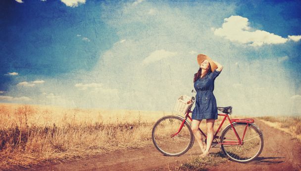 barna lány kerékpár úton vidéken. - Fotó, kép