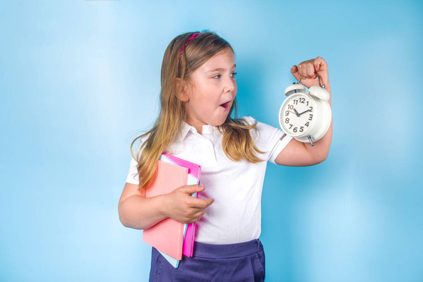 Back to school, invitation, advertisement banner.  Cute primary school student girl in white blue uniform, with books, alarm clock. Time to Learn, school sale concept - Φωτογραφία, εικόνα