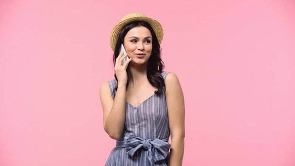 Young woman in sun hat talking on mobile phone isolated on pink  - Foto, imagen