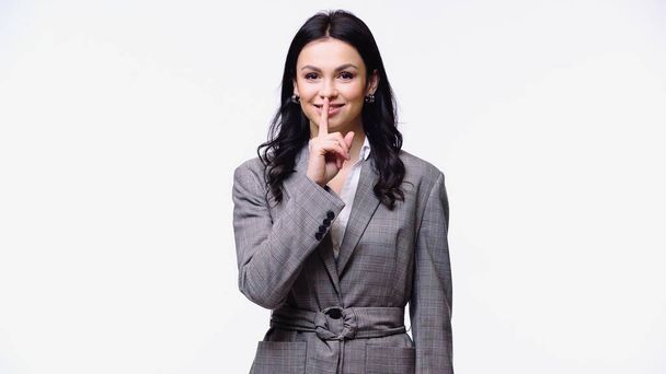 Smiling businesswoman showing secret gesture isolated on white - Photo, Image