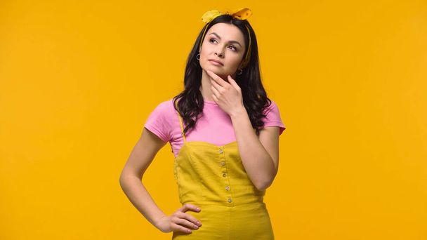 Pensive woman in headband looking away isolated on yellow - Photo, Image