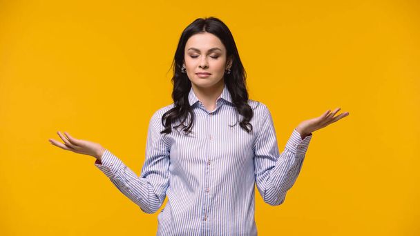 Businesswoman with closed eyes pointing with hands isolated on yellow - Photo, Image