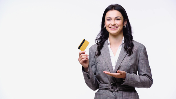 Happy businesswoman pointing at credit card isolated on white  - Фото, изображение