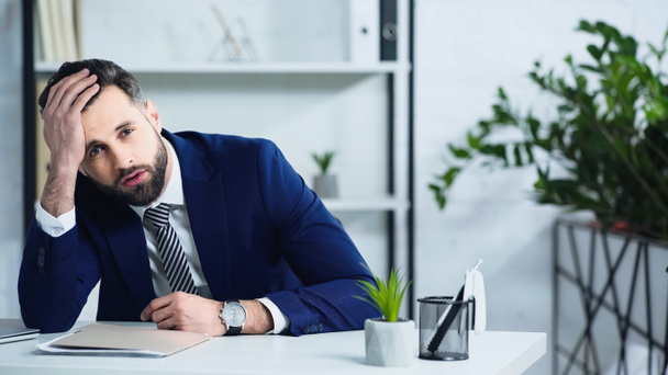frustrated businessman in suit sitting in office  - Фото, зображення