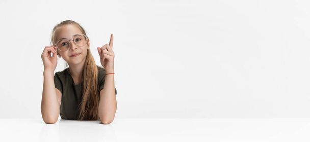 Flyer. One beautiful teen school caucasian girl in casual clothes and glasses isolated over white studio background. - Foto, Imagen
