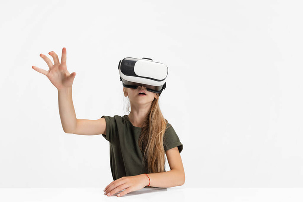 Одна умная девочка-кавказка из школы подростков в очках VR изолирована на белом фоне студии. - Фото, изображение
