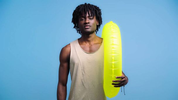 african american man with inflatable ring isolated on blue - Fotó, kép